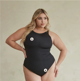 Pinsy Shapewear Shapesuits have 5 distinct features. This photo shows a model with her front to the camera wearing a thong shapesuit with a high neck in black. The numbers 4 (at her crotch) 5 (at her bust) display where our patented features are
