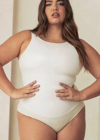 Woman Wearing Pinsy Shapewear Vegan Leather High Neck Shapewear Bodysuit in White