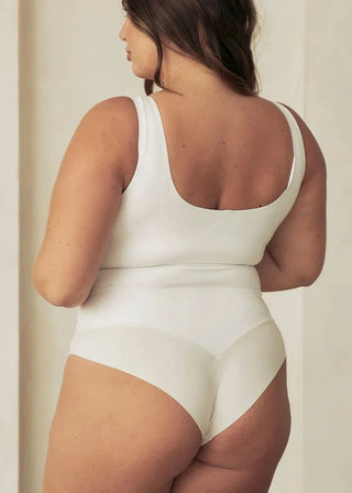 Woman Wearing Pinsy Shapewear Vegan Leather High Neck Shapewear Bodysuit in White